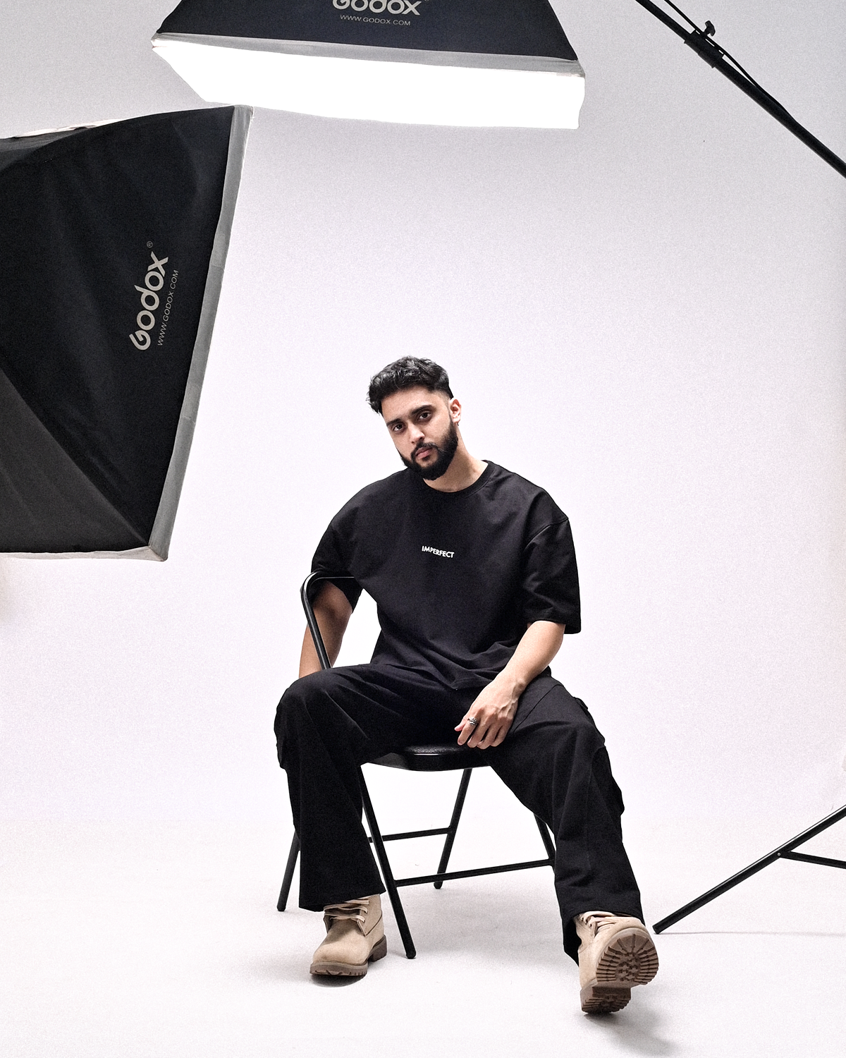Man sitting on a chair in a studio with photography equipment
