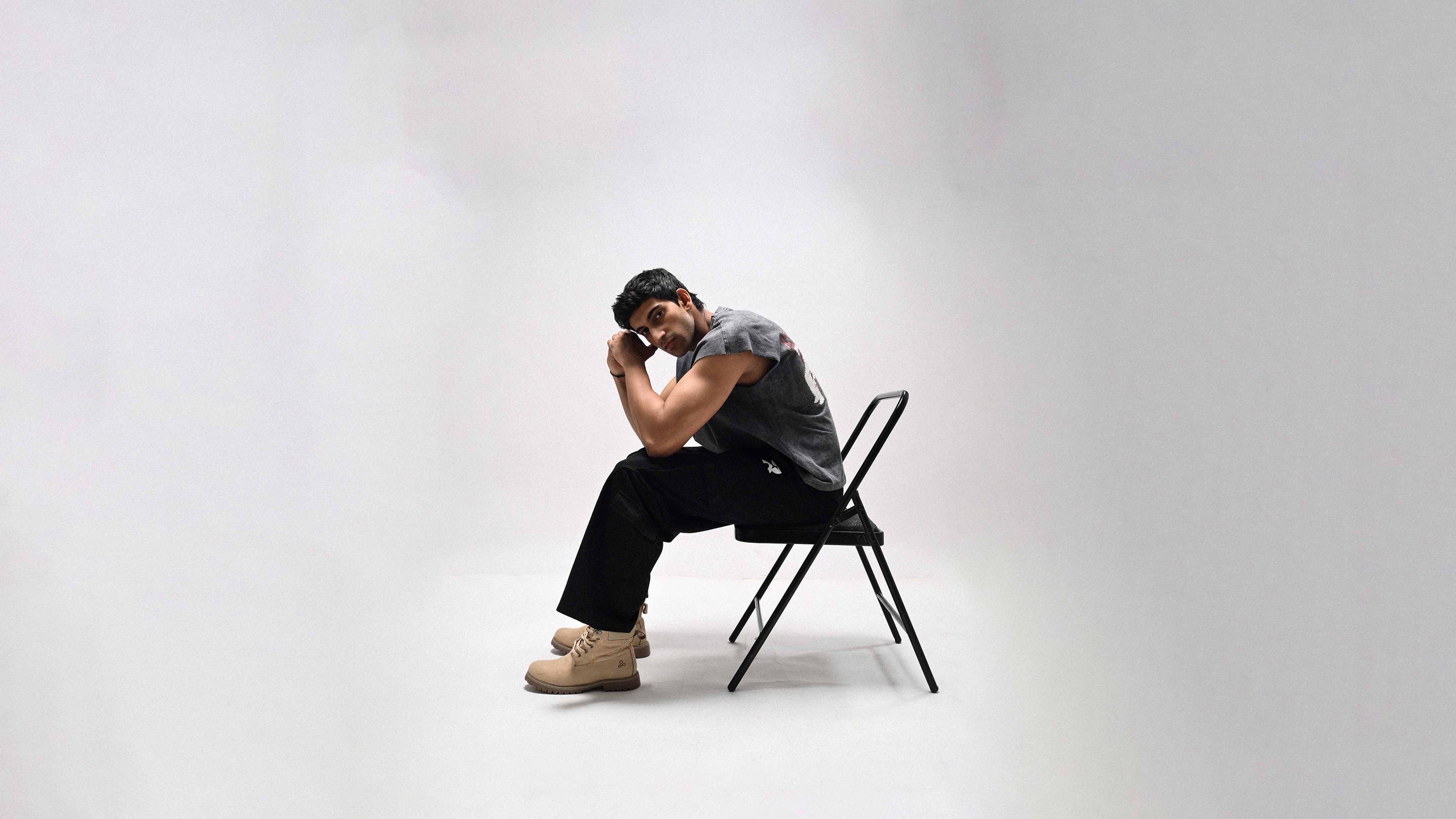 Person sitting on a chair against a plain background
